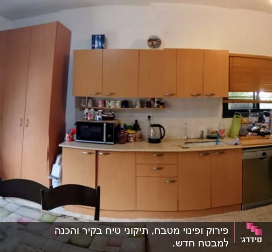 מטבח עם ארונות עץ, שולחן אוכל, ומכשירי חשמל